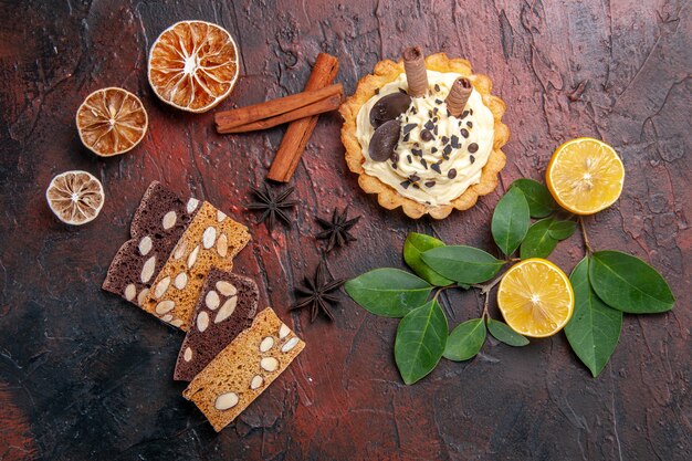 Draufsicht leckerer cremiger Kuchen mit Kuchen auf dunklem Tischdessert süßer Kekskuchen