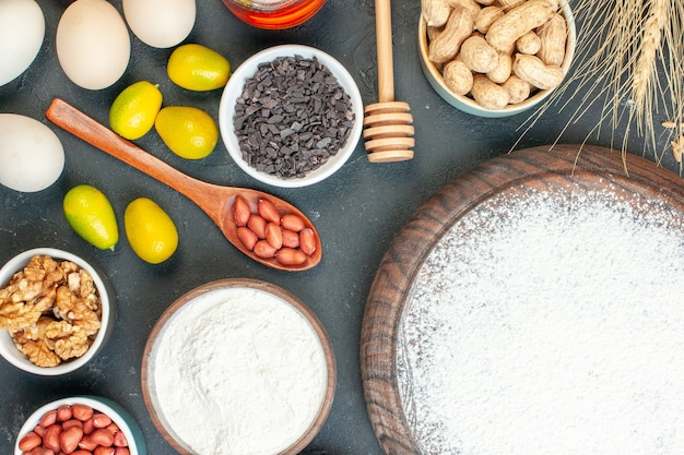 Kostenloses Foto draufsicht leckerer fruchtiger kuchen mit mehl und nüssen auf dem dunklen fruchtsüßkuchen zuckerteegebäck dessert kekskuchen