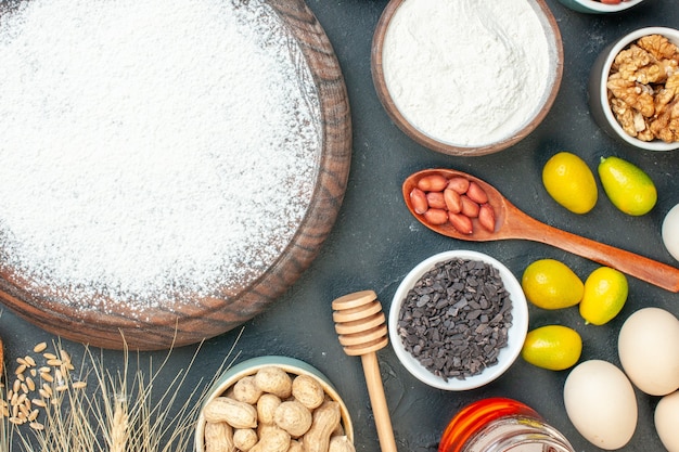 Draufsicht leckerer fruchtiger Kuchen mit Mehl und Nüssen auf dem dunklen Fruchtsüßkuchen Zuckerteegebäck Dessert Kekskuchen