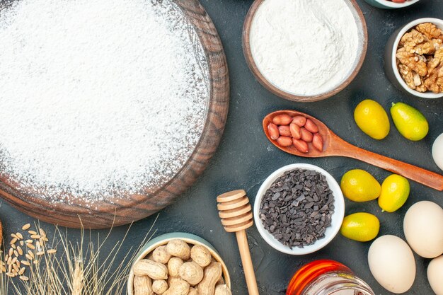 Draufsicht leckerer fruchtiger Kuchen mit Mehl und Nüssen auf dem dunklen Fruchtsüßkuchen Zuckerteegebäck Dessert Kekskuchen