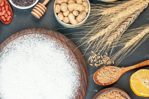 Draufsicht leckerer fruchtiger Kuchen mit Mehl und Nüssen auf dunklem Obst süßer Kuchen Zuckerkuchen Tee Dessertkeks