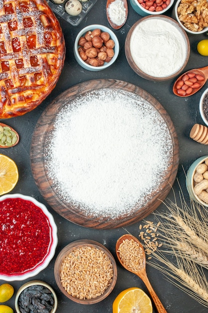 Draufsicht leckerer fruchtiger Kuchen mit Mehlnüssen und Marmelade auf einem dunklen Keks süßer Kuchen Keks Zuckerkuchen Tee Gebäck Dessert