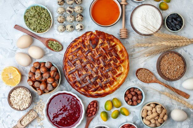 Draufsicht leckerer fruchtiger Kuchen mit Nüssen und Eiern auf leicht gebackenem Kekskuchen Dessertfarbe Teekuchen Keks Bäckerei Brötchen