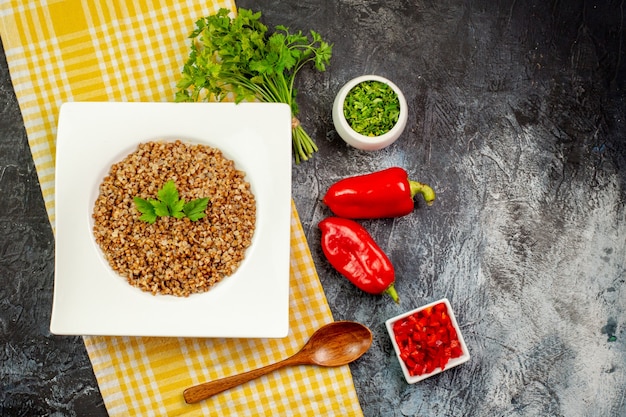 Kostenloses Foto draufsicht leckerer gekochter buchweizen mit gemüse und paprika auf dem hellgrauen tisch