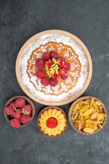 Draufsicht leckerer Himbeerkuchen mit Rosinen auf grauer Oberfläche Keks Tee süßer Kuchen Zucker