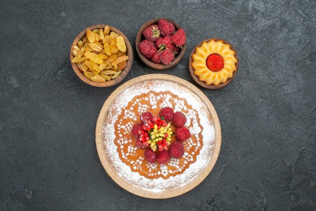 Draufsicht leckerer Himbeerkuchen mit Rosinen auf grauer Oberfläche Zuckertee Kekskuchen Cookie süße Torte