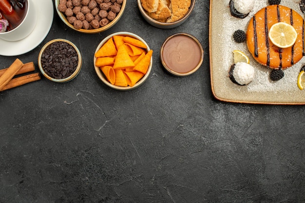 Draufsicht leckerer kleiner Kuchen mit Tasse Tee auf dunkler Oberfläche Cookie Süßigkeiten Keks Kuchen Kuchen süß