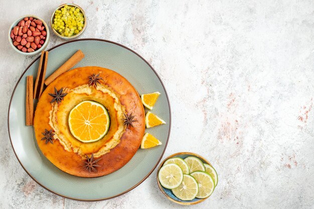 Draufsicht leckerer Kuchen leckeres Dessert für Tee mit Orangenscheiben auf weißem Hintergrund Obstkuchen Kuchen Keks süßes Dessert