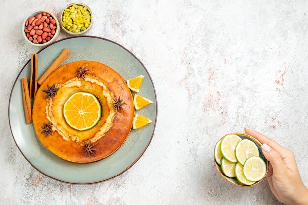 Draufsicht leckerer Kuchen leckeres Dessert für Tee mit Orangenscheiben auf weißem Hintergrund Obstkuchen Kuchen Tee Keks süßes Dessert