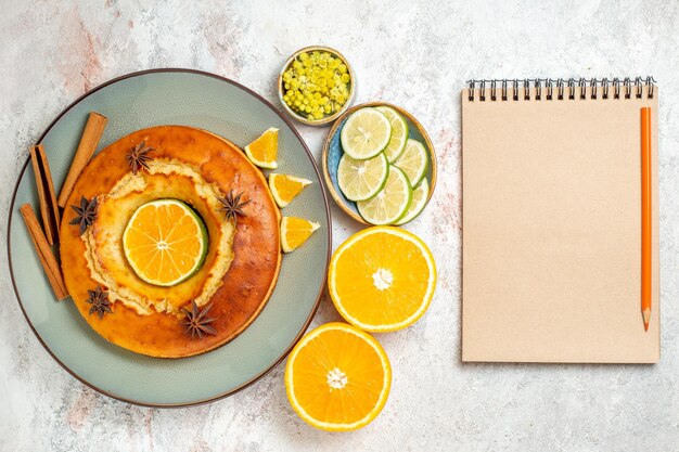 Draufsicht leckerer Kuchen leckeres Dessert für Tee mit Zitrone und Orange auf dem weißen Hintergrund Obstkuchen Kuchen Tee Keks süßes Dessert