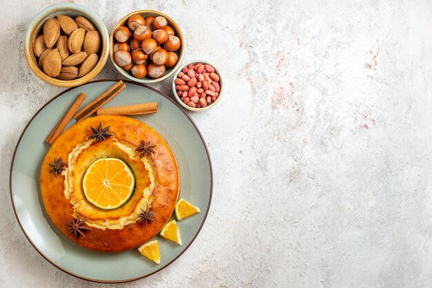 Draufsicht leckerer Kuchen mit Nüssen und frischen Zitrusfrüchten auf weißem Hintergrund Obst süßer Nusskuchen Kuchen Keks