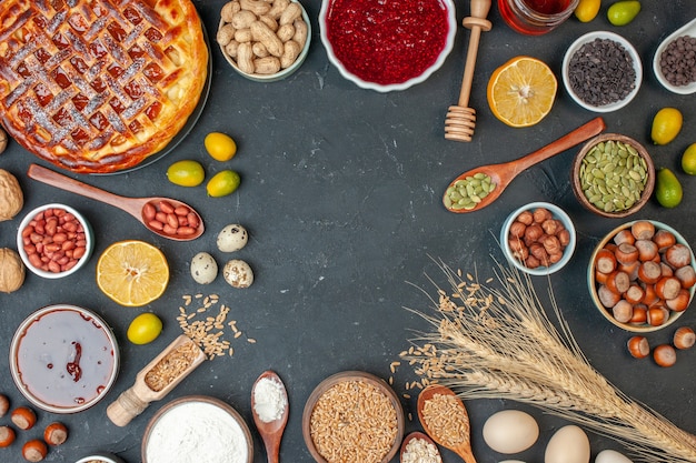 Kostenloses Foto draufsicht leckerer obstkuchen mit eiern und nüssen auf dunklem donut fotokuchen rosinenkekskuchen dessert