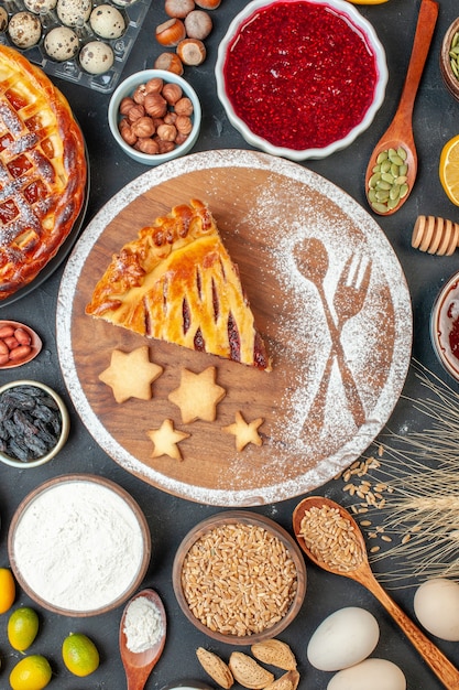 Draufsicht leckerer Obstkuchen mit Marmeladennüssen und Mehl auf dem dunklen Keks Dessertkuchen Teekuchenteig süßer Backzucker