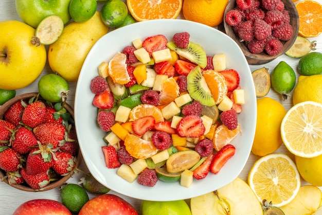 Draufsicht leckerer Obstsalat mit verschiedenen Früchten auf weißem Hintergrund