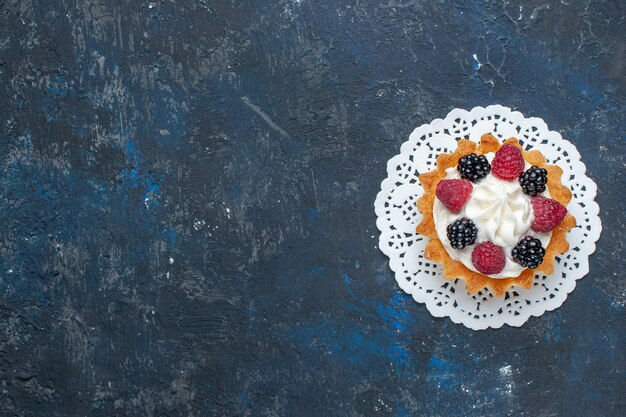 Draufsicht leckerer süßer Kuchen mit verschiedenen Beeren und Sahne auf dem dunkelgrauen Schreibtischfruchtbeerenfarbkuchen-Keks süß