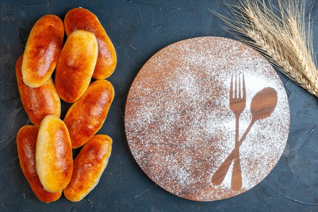 Draufsicht leckeres Abendessen Brötchen Gabel und Löffel Aufdruck in Puderzucker auf Holzbrett