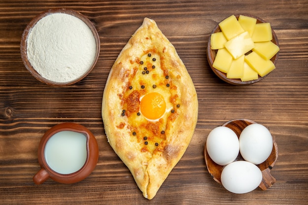 Draufsicht leckeres Eierbrot frisch aus dem Ofen auf dem braunen Schreibtischteigbrotbrötchenfrühstück