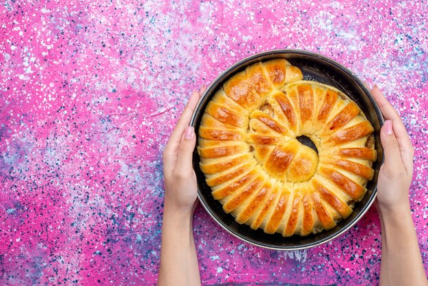 Draufsicht leckeres gebackenes Gebäck köstlicher Armreif gebildet in Pfanne auf dem hellen Schreibtisch Gebäckplätzchen Keksteig süßer Zucker