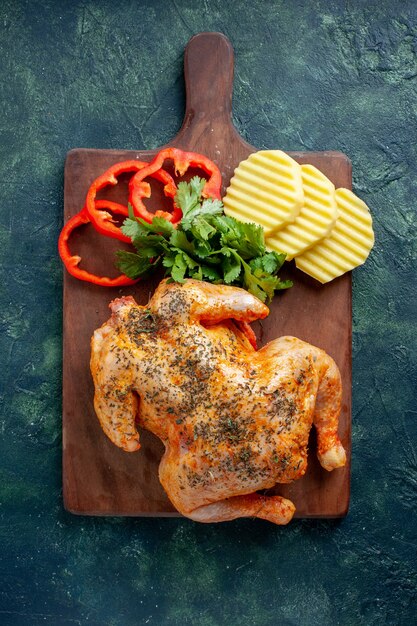 Draufsicht leckeres gekochtes Hühnchen gewürzt mit Kartoffeln und geschnittenem Pfeffer auf dunklem Hintergrund Fleischfarbe Gericht Abendessen Essen Grill