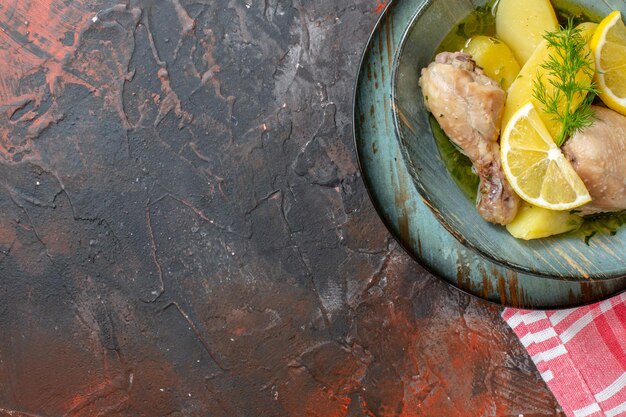 Draufsicht leckeres gekochtes Hühnchen mit gekochten Kartoffeln und Zitrone auf dunklem Hintergrund Farbe Lebensmittelsauce Fleischgericht Fotokalorien-Abendessenöl