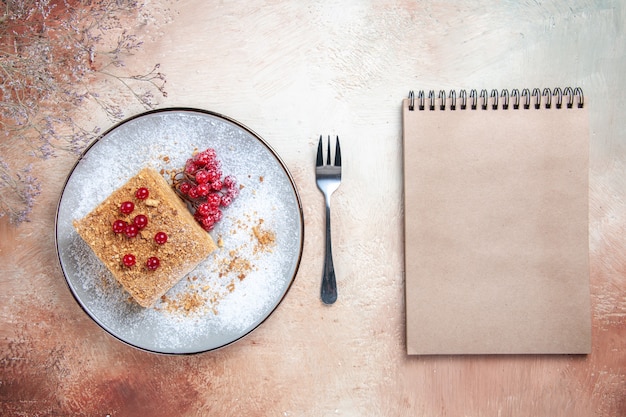 Draufsicht leckeres Kuchenstück mit roten Beeren am Licht