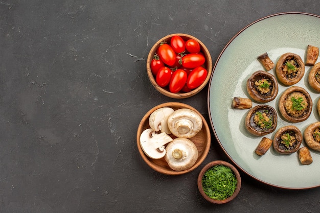 Draufsicht leckeres pilzessen mit frischen tomaten und grüns auf dunklem oberflächengericht abendessen mit pilzen