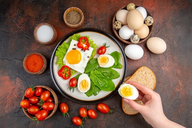 Draufsicht leckeres Sandwich mit gekochten Eiern und Tomaten auf dunklem Tisch