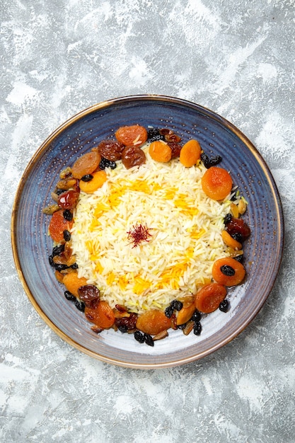 Draufsicht leckeres shakh plov gekochtes Reisgericht mit Rosinen innerhalb Platte auf Weiß