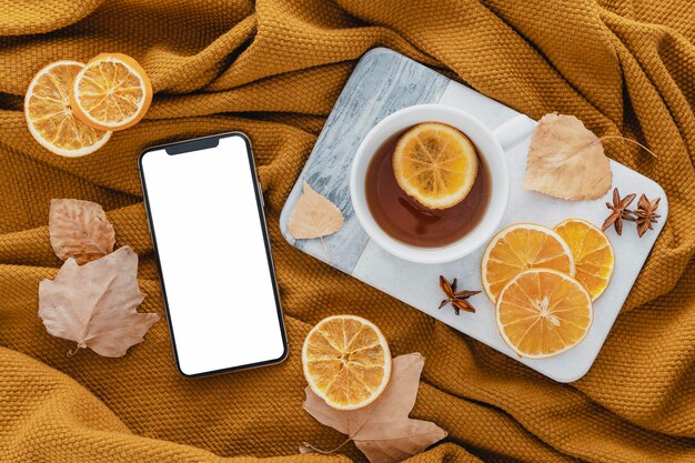 Kostenloses Foto draufsicht leeres telefon mit tee und getrockneten zitronenscheiben