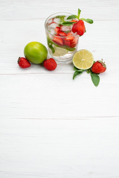 Draufsicht Limette und Erdbeeren frisch und weich mit Glas Wasser auf weißen Fruchtbeerengetränk Zitrusfrüchten