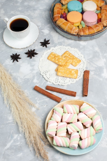 Draufsicht Marshmallows und Tee mit Bagels und Macarons auf weißem Schreibtisch