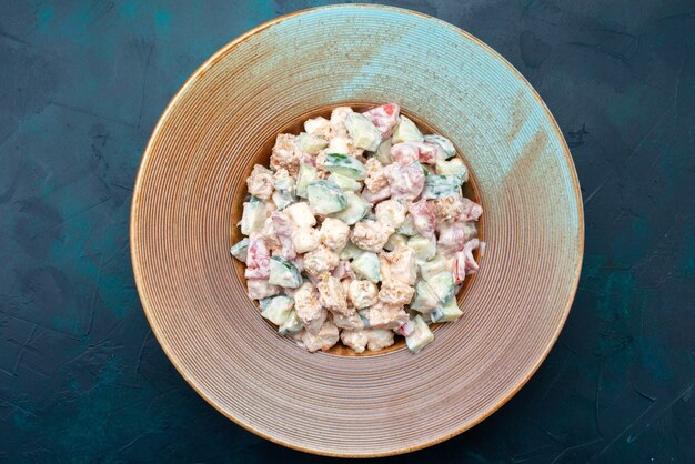 Draufsicht Mayonaised Salat geschnittenes Gemüse innerhalb Platte auf dem dunkelblauen Hintergrund Salat Essen Mahlzeit