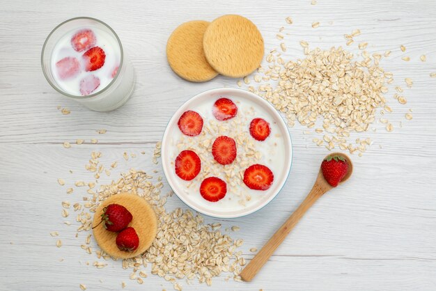 Draufsicht Milch mit Haferflocken Innenplatte mit Erdbeeren zusammen mit Glas Milch auf weißer Milchmilch Frühstücksgesundheit