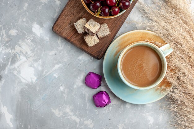 Draufsicht Milchkaffee mit Waffeln frische Sauerkirschen auf dem hellen Hintergrundplätzchen süßer Zucker backen Frucht