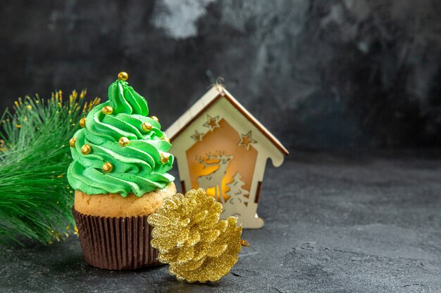 Draufsicht Mini Weihnachtsbaum Cupcake Weihnachtsbaum Zweig Laterne goldener Tannenzapfen auf dunkler Oberfläche