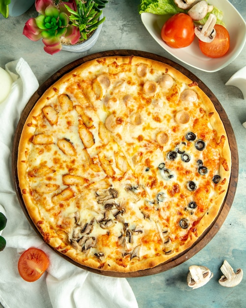 Kostenloses Foto draufsicht mischen pizza mit hühnerwürsten, pilzen und oliven auf dem brett