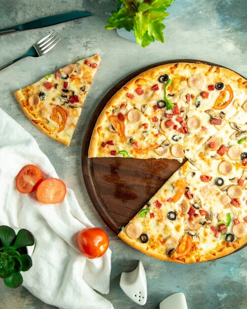 Draufsicht mischen Pizza mit Hühnerwürsten, Pilzen und Oliven auf dem Brett