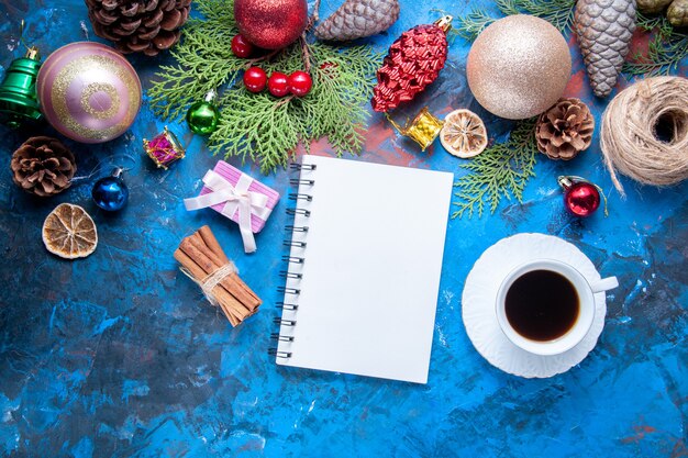 Draufsicht Notizbuch Tannenbaum Zweige Kegel Weihnachtsbaum Spielzeug auf blauer Oberfläche