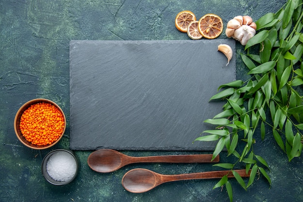 Draufsicht orange Linsen mit Knoblauch und Salz auf dunkelblauem Hintergrund Foto Essen würzige scharfe Paprika Farbe scharfe Samen Suppe