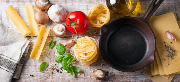 Draufsicht pfanne zu braten neben verschiedenen arten von pasta