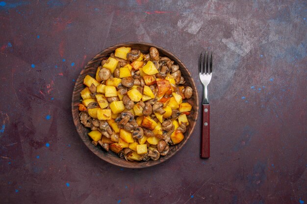 Draufsicht pilze mit kartoffeln in der mitte liegen pilze mit kartoffeln in einer schüssel auf der dunklen oberfläche