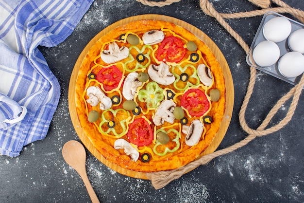 Draufsicht Pilzpizza mit Tomatenolivenpilzen mit Eiern auf dem dunklen Schreibtischpizzateig italienisches Essen