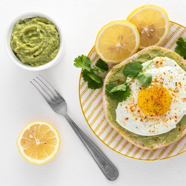 Draufsicht Pita mit Avocadoaufstrich und Spiegelei auf Teller mit Gabel