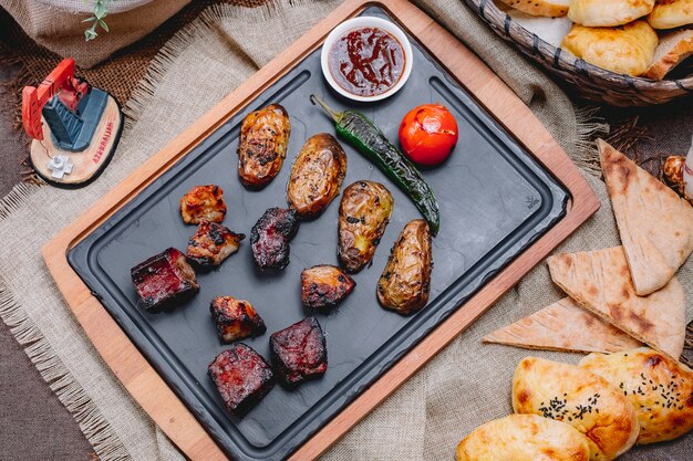 Draufsicht Rinderleber Kebab mit Kartoffeln und Tomate mit gegrilltem grünem Pfeffer und Soße auf einem Tablett