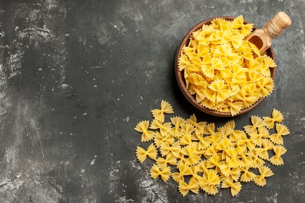 Draufsicht rohe italienische Pasta im Teller auf dunkelgrauem Hintergrund