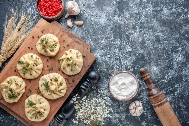 Draufsicht rohe kleine Knödel auf hellgrauem Hintergrund Fleischteigmehlkuchen-Kochgeschirrküchenabendessen