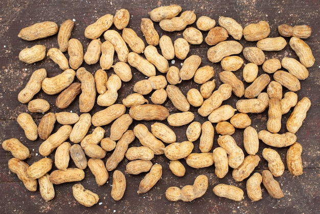 Kostenloses Foto draufsicht rohe nüsse hell und lecker auf braunem nuss-walnuss-mandel-snack