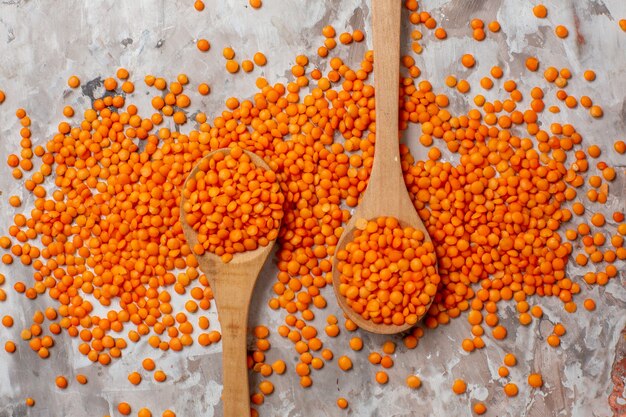 Draufsicht rohe orangefarbene Linsen auf heller Oberfläche Pflanzensuppe Foto Lebensmittelsamen