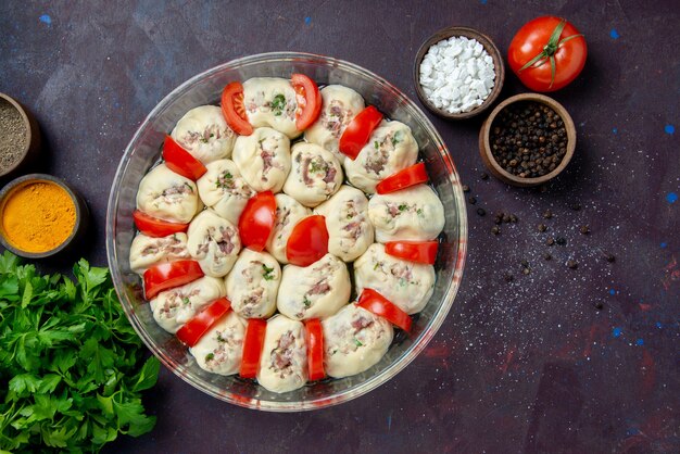 Draufsicht rohe Teigstücke mit Hackfleischtomaten und Gewürzen auf dunkler Mahlzeit Küche Salatschüssel Küche Foto Farbe Lebensmittel