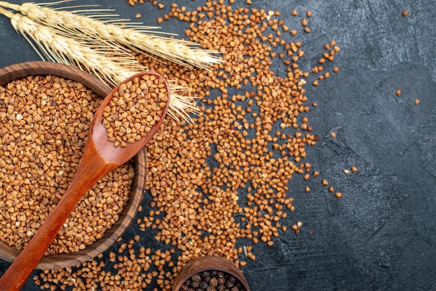 Draufsicht roher Buchweizen frische Zutaten in brauner Platte auf grauem Raum